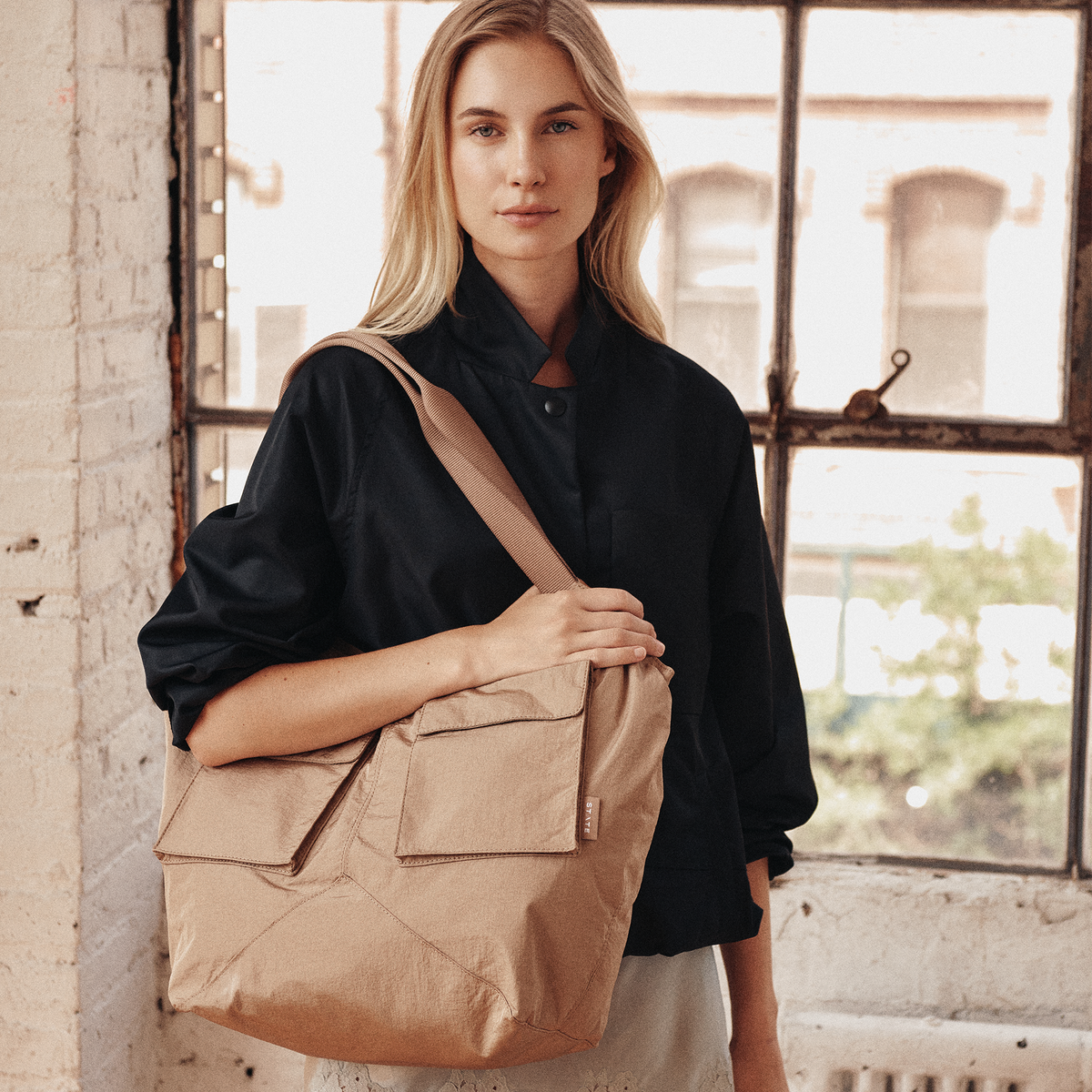 Image showing woman wearing STATE Bags Beverly Tote Crinkled Nylon Affogato 