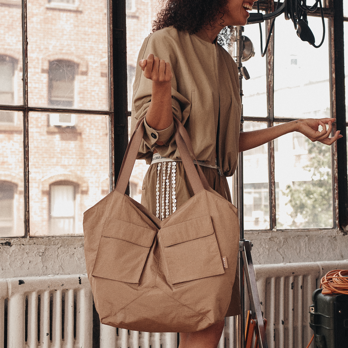 Image showing woman wearing STATE Bags Beverly Tote Crinkled Nylon Affogato 