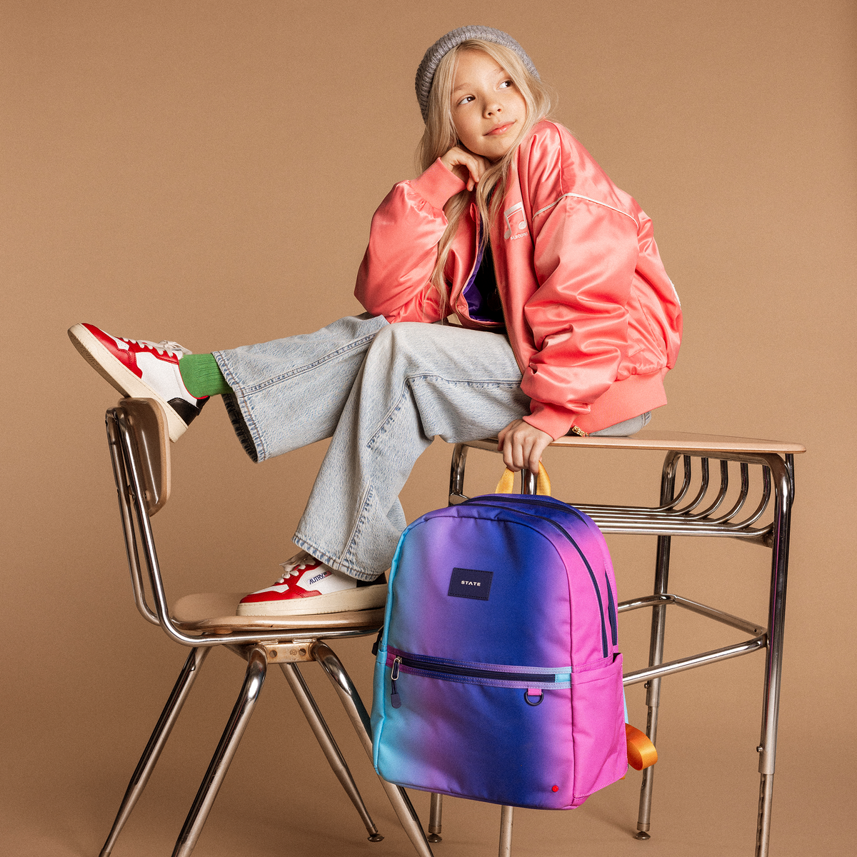 girl holding kane blue pink gradient while sitting on desk