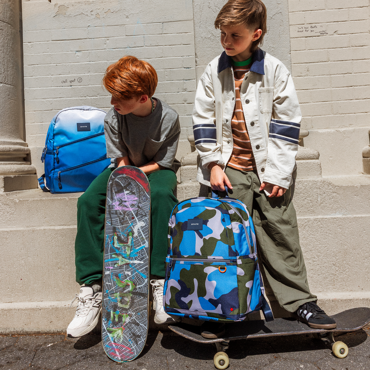 Boys with skateboards outside with STATE bags kane double pockets