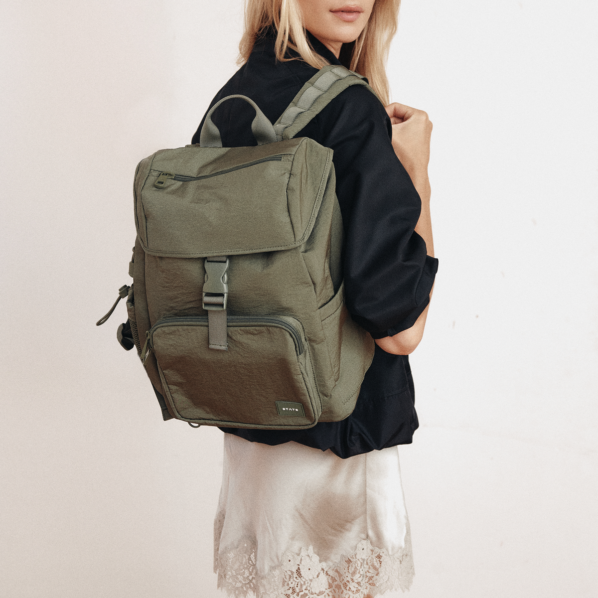 Woman wearing STATE Bags Nevie Backpack Olive