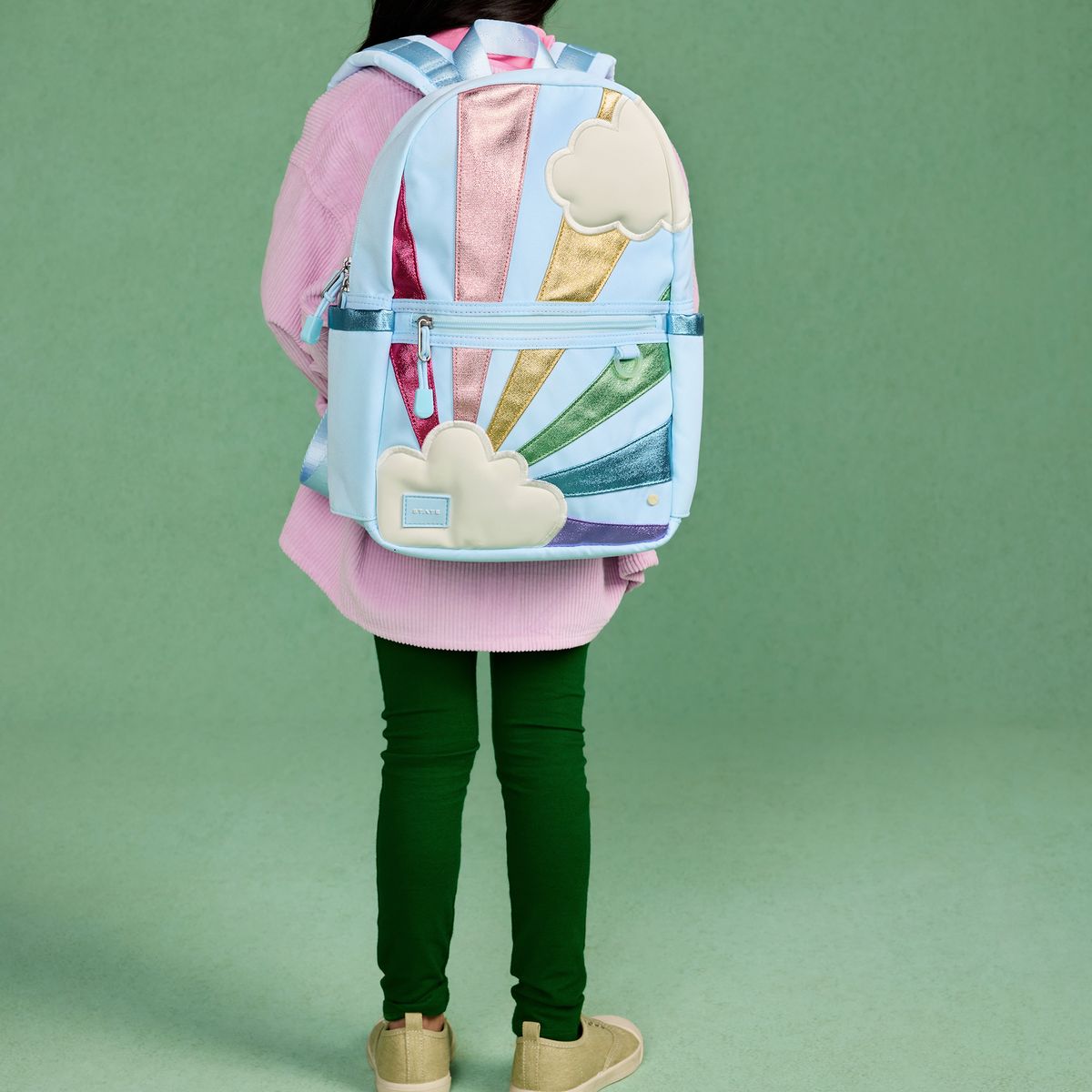 girl wearing STATE Bags Kane Mini Backpack Rainbow Clouds