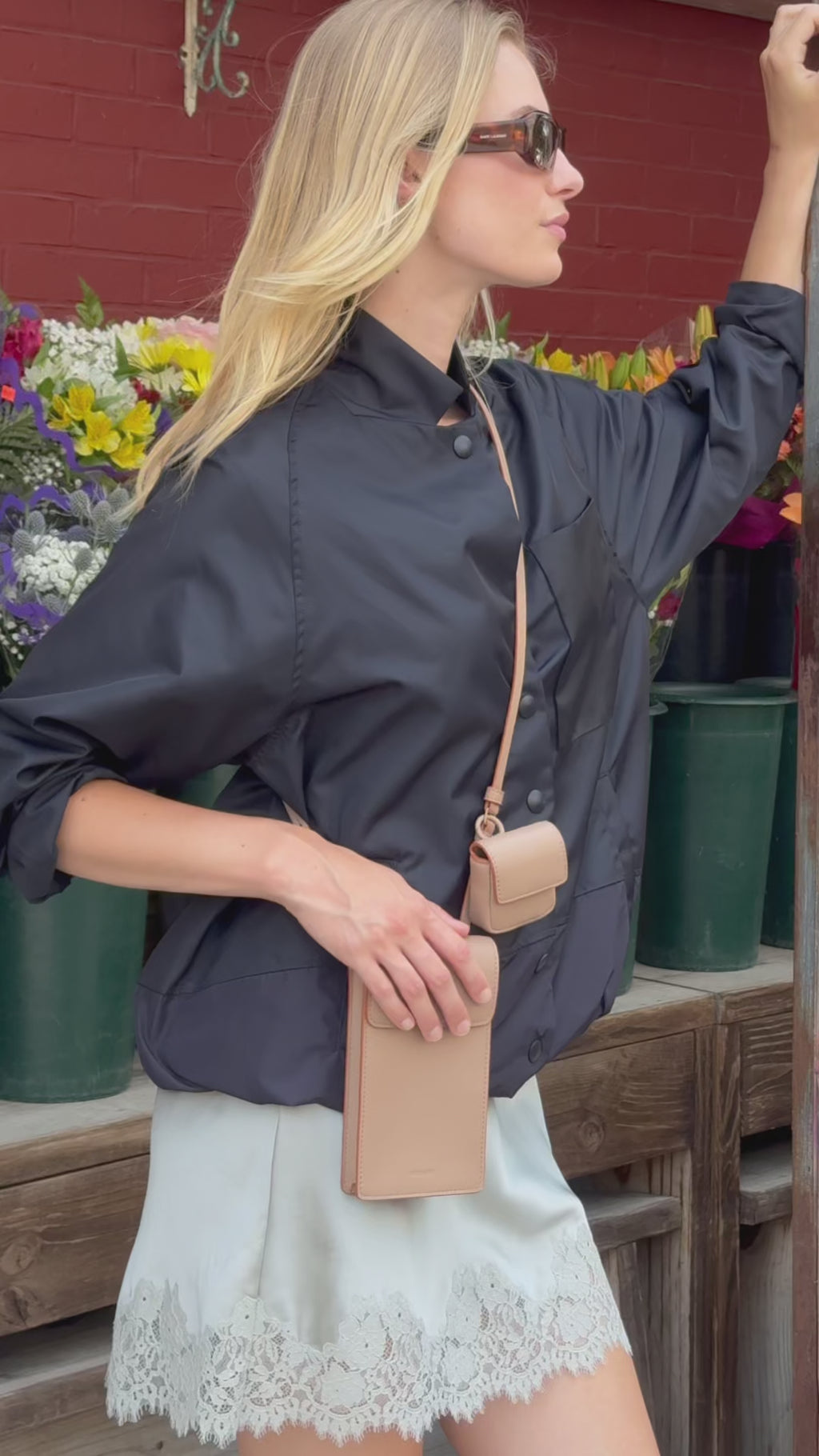 STATE Bags Georgia Phone Sling Affogato being worn by a woman outside